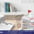 Desk with a power of attorney document, insurance claim files, cash bundles, and a computer screen showing claim information